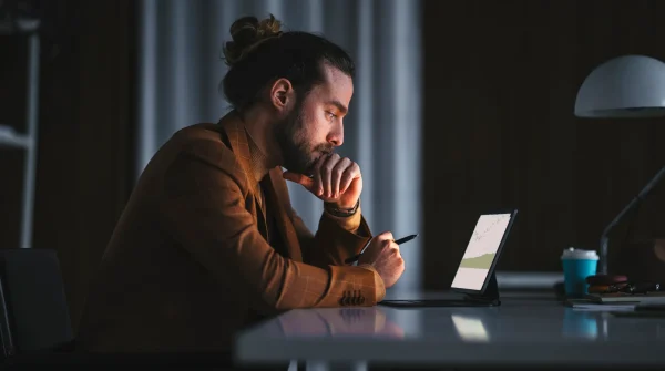 Selbstständiger Mann arbeitet am Tablet bei Nacht – Symbolbild zur Altersvorsorge Selbstständige Pflicht